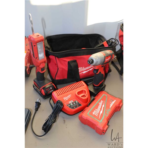 Milwaukee 12 volt driver with some bits, an 18 volt flashlight with batteries and chargers plus a ca