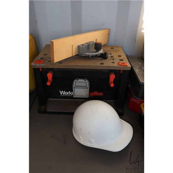 Workman TopBox portable work surface with a selection of assorted tools and hardware plus a white ha