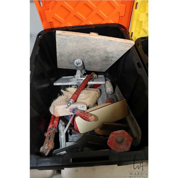 A selection of concrete finishing tools including floats, chisels, brushes, joint groover tools, and