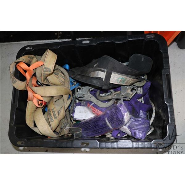 A selection of fall arrest equipment including ropes, caribiners, straps, and a black tote