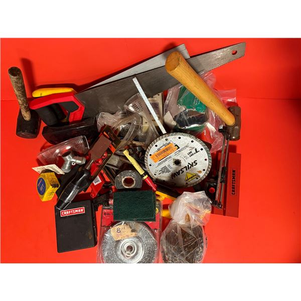 collection of various tools, including hand saws, a tape measure, hammers, and several saw blades
