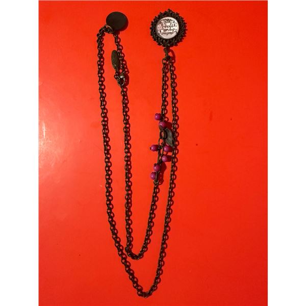 layered chain necklace with a circular pendant and pink bead accents