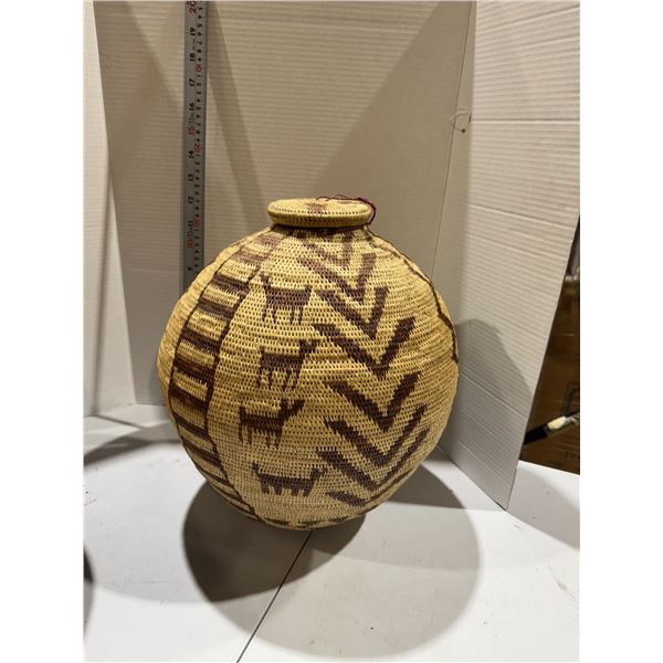 handwoven coiled basket with a lid, featuring stylized animal and geometric patterns in natural and