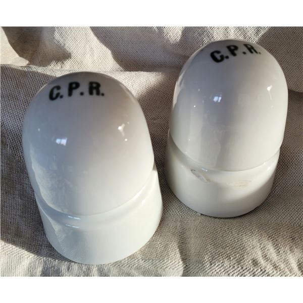 Two white CPR insulators with grey green C.P.R. lettering