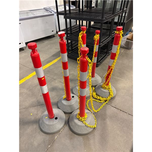 Five Red Traffic Delineator Posts With Yellow Chains