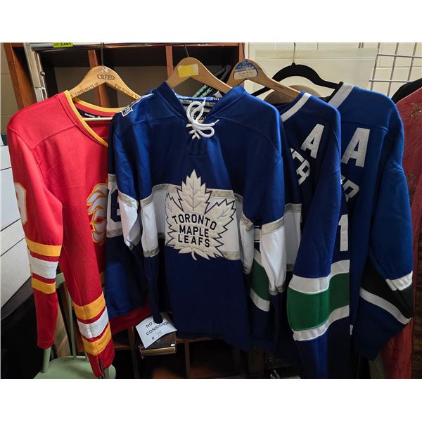3 Vancouver Canucks Jerseys (2 with an A) and 1 Calgary Flames Jersey