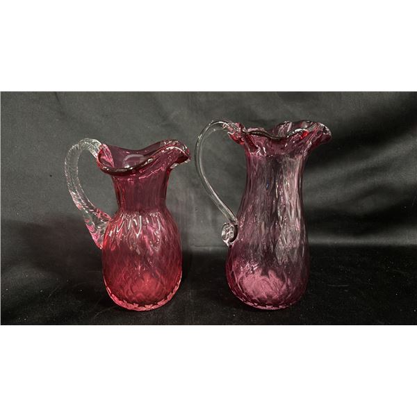 (2) CRANBERRY GLASS PITCHERS WITH CLEAR GLASS HANDLES: TALLEST IS 7.5"