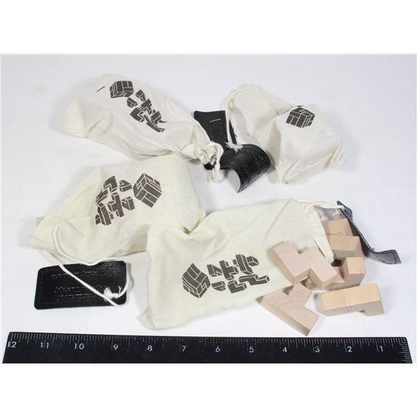 FOUR WOODEN BLOCK PUZZLES IN CLOTH BAGS