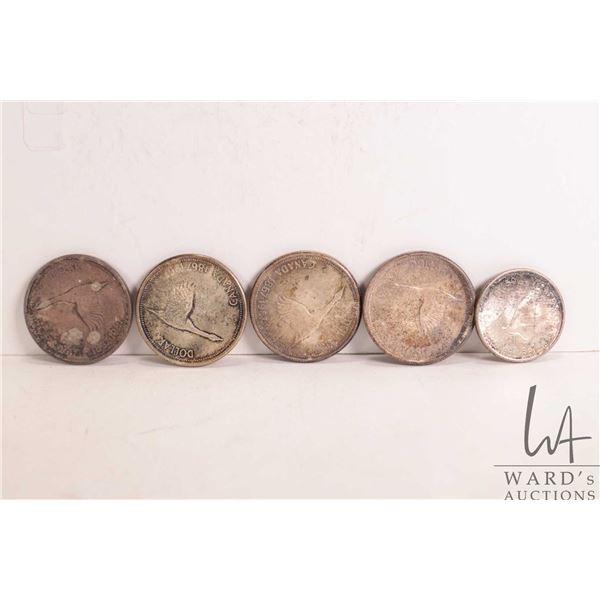 Five Canadian 1967 coins including four $1 and one .50 cent