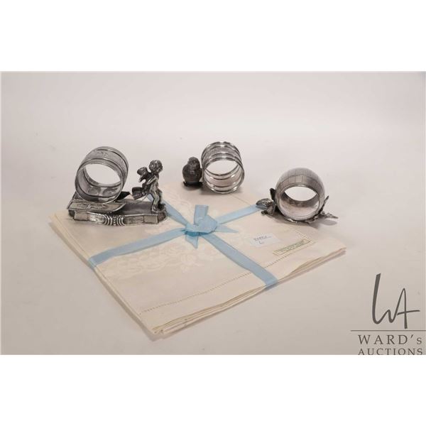 Three antique Victorian silver plate napkin holders including cherub pulling a sledge, Easter chick 