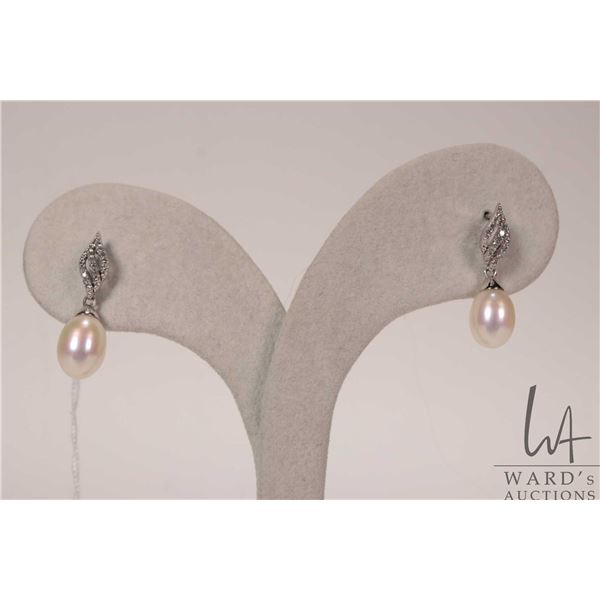 10kt white gold and fresh water cultured pearl earring set with single cut round diamonds. Retail re