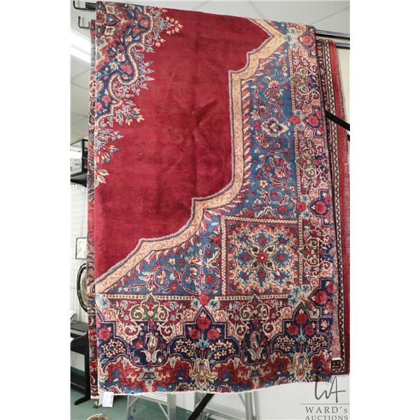 Iranian wool carpet "Mashad" with center medallion on red background with floral border and highligh