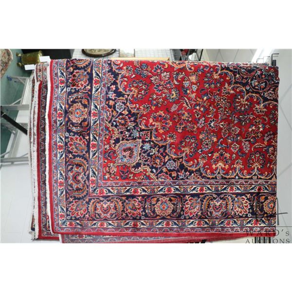 Iranian wool carpet "Mashad" with center medallion on red background with overall floral design and 