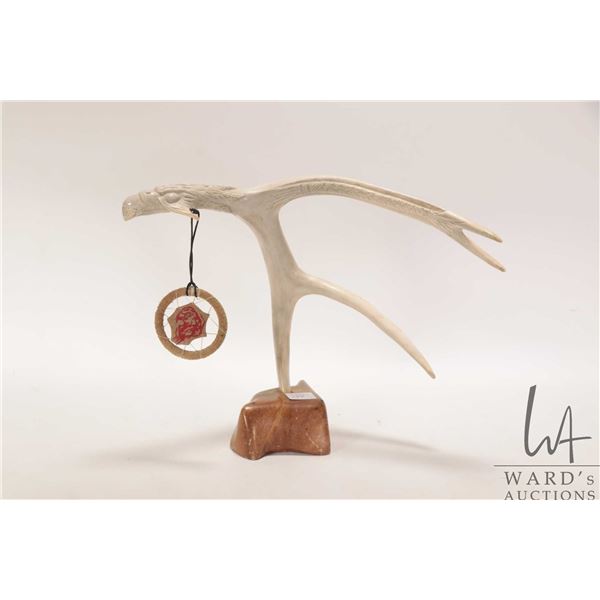 Indigenous hand carved antler eagle on stone base, signed by artist and 9 3/4" in height