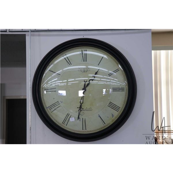 Convex glass battery operated wall clock with metal frame measures 24" in diameter
