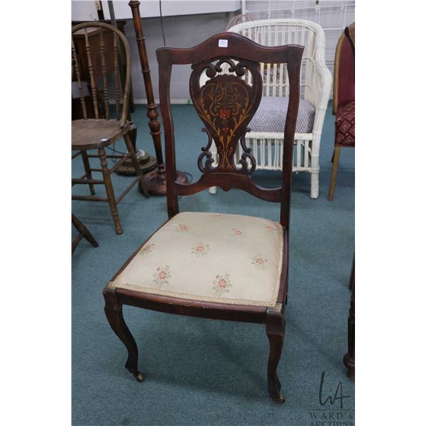 Antique side chair with floral decorated back and brass castors