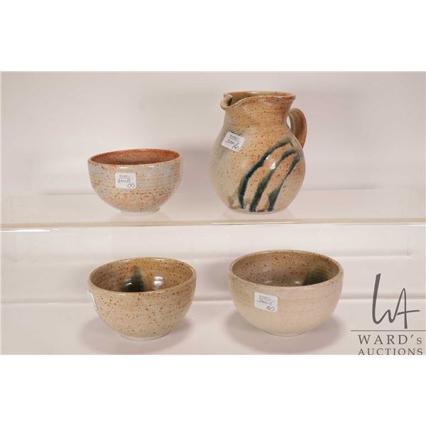 Four artisan made pieces of pottery including 6" high pitcher and three approximately 5" diameter bo