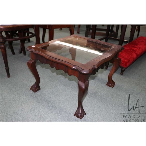 Coffee table height, wooden end table with glass top and carved ball and claw feet. See photo for fa