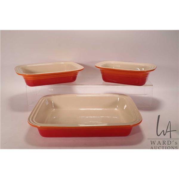 Three Le Creuset stoneware baking dishes including loaf pan, 12" casserole dish and a 15" lasagna pa