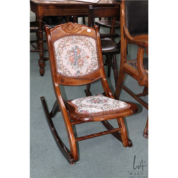 Folding nursing rocker with carved back and tapestry upholstered seat and back
