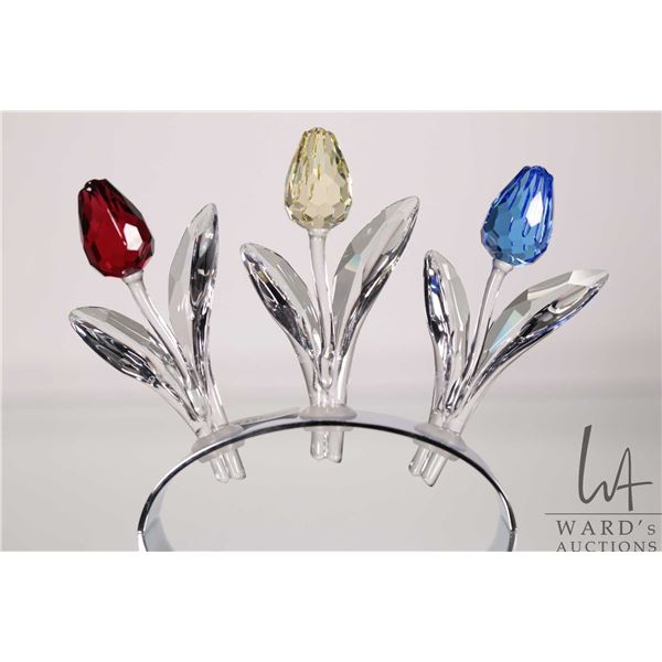 Swarovski crystal set of three coloured tulips on reflective oval stand. Includes original boxes