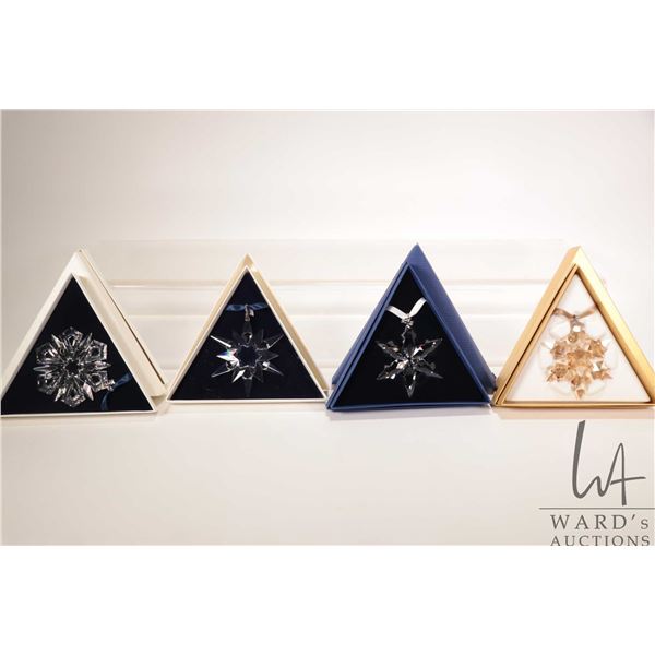 Four Swarovski crystal Christmas ornaments including 1997, 1999, 2010 and 2016
