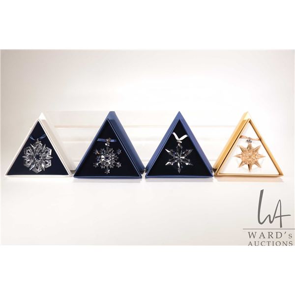 Four Swarovski crystal Christmas ornaments including 1999, 2004, gold 2009 and 2015