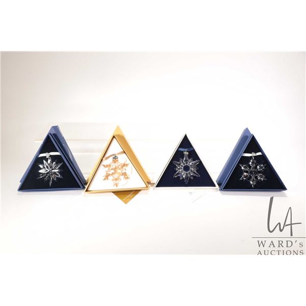 Four Swarovski crystal Christmas ornaments including 1998, 2010 gold and 2010 clear and 2011