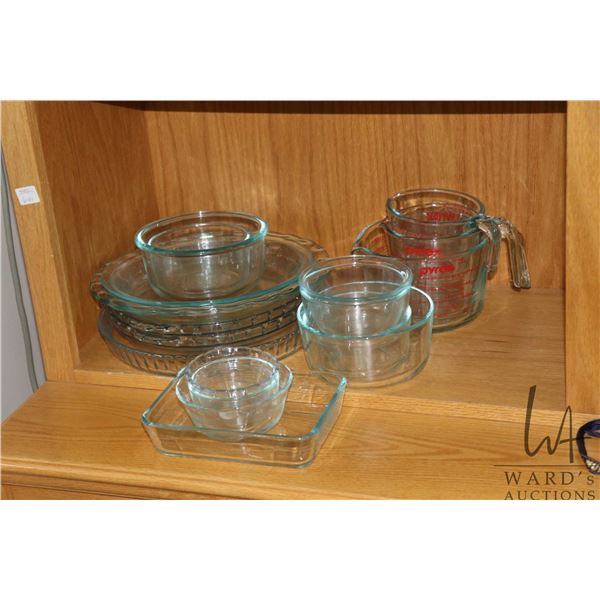 Selection of vintage Pyrex cookware including four pie plates ten clear refrigerator boxes, and thre
