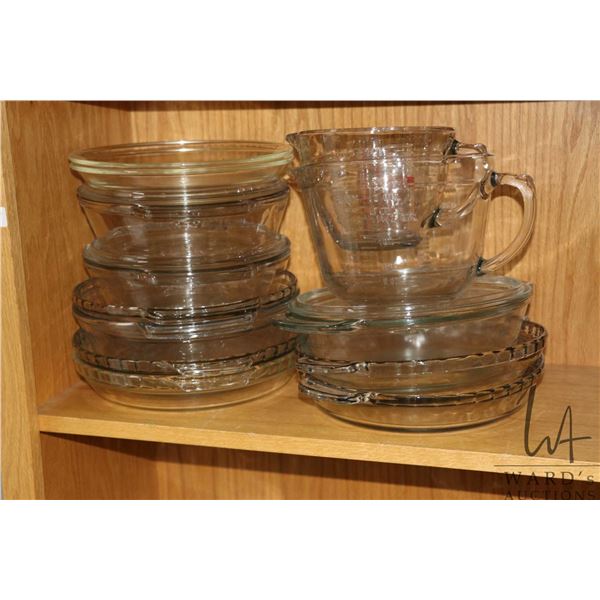 Selection of Anchor Hocking glass cookware including three lidded casserole dishes, six pie plates, 