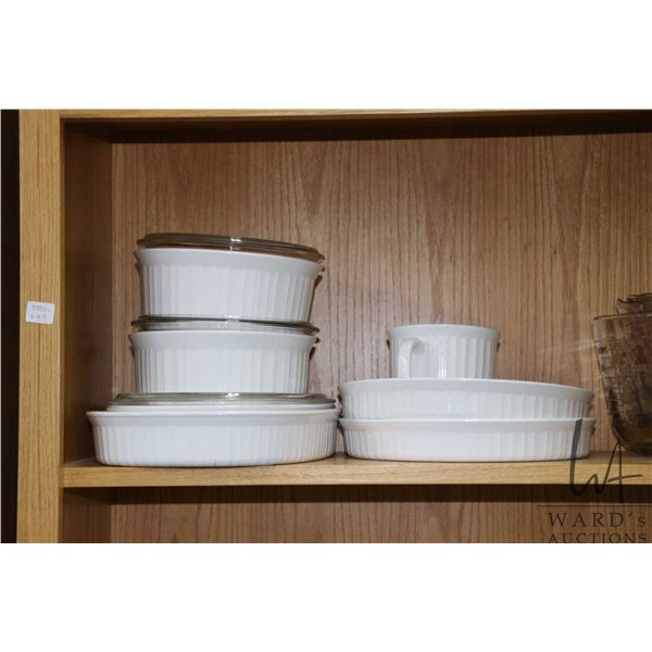 Selection of vintage cookware including three lidded casserole dishes, two pie plates, large oval se