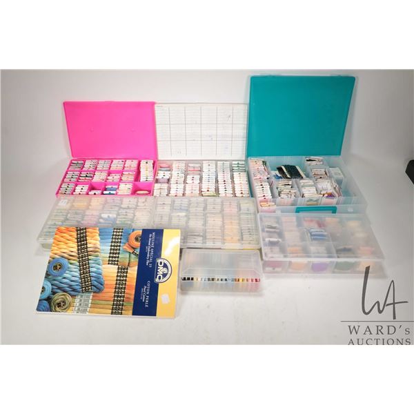 Six plastic floss holders filled with assorted embroidery floss plus a DMC colour guide