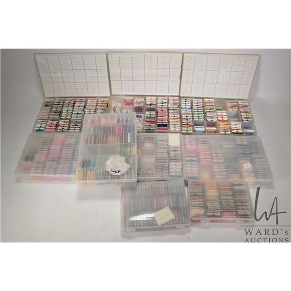 Nine plastic floss holders filled with assorted embroidery floss