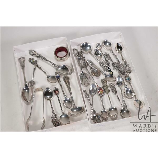 Two trays of sterling silver and silverplate collectible spoons and a set of hallmarked sugar tongs