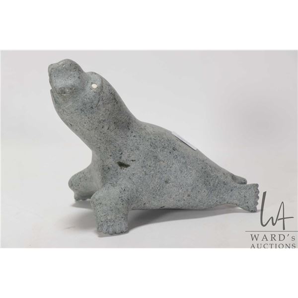 Inuit soapstone carving of a seal with inlaid bone eyes, no artist signature seen, 5 3/4" in height