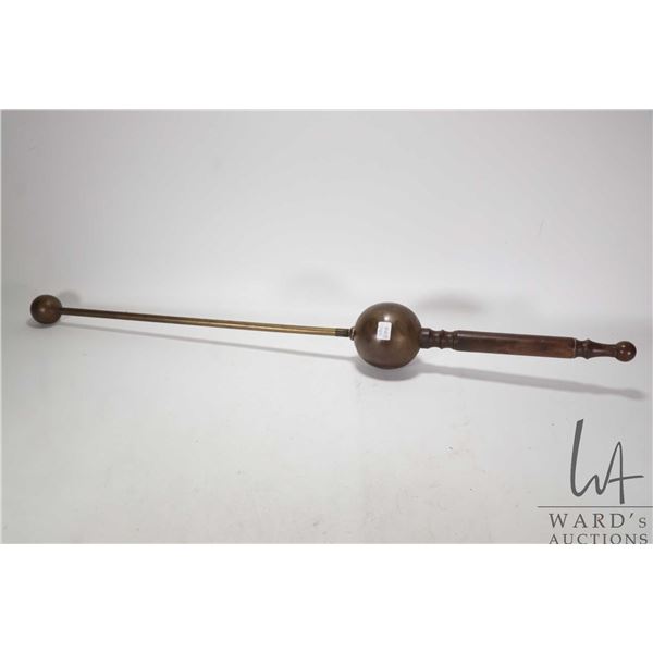 Antique brass instrument with heavy weighted ball on one end, large brass float and wooden handle. C
