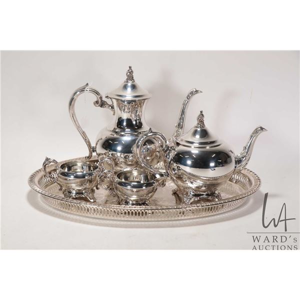 Silver plate tea service including tea and coffee pots, lidded cream and sugar and a decorative scro