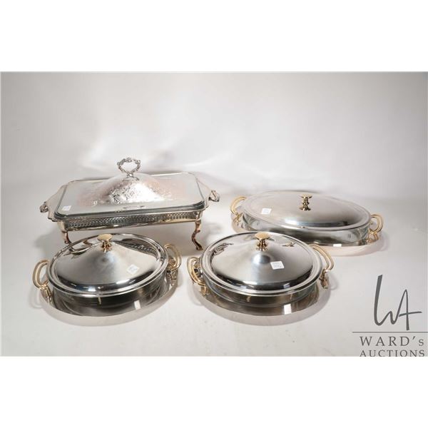 Three silver plate and gold tone gold toned casserole dishes with glass liners and under trays and a
