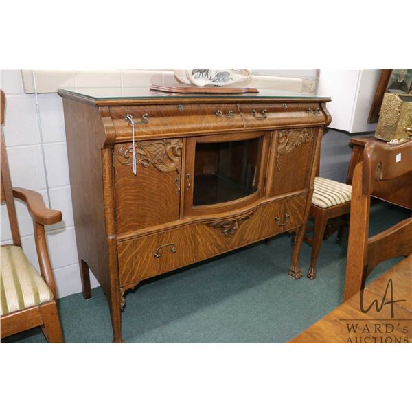 Antique Canadiana sideboard with curved glass door, carved paw feet and carved accents including Gre