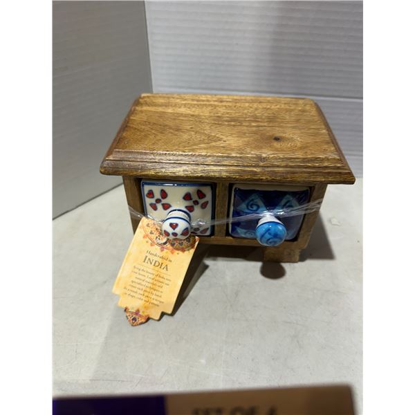small, handcrafted wooden chest with two hand-painted ceramic drawers