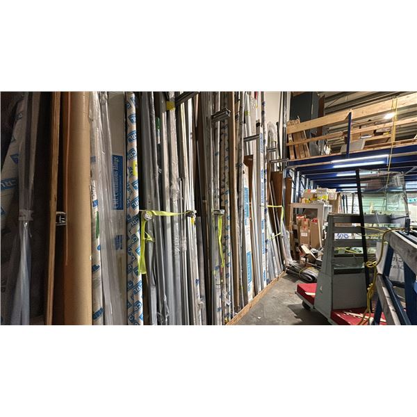 LARGE GROUP OF ALUMINUM EXTRUSIONS LEANING ON WALL IN BAY 1. INC WALL DIVIDING HARDWARE WHICH
