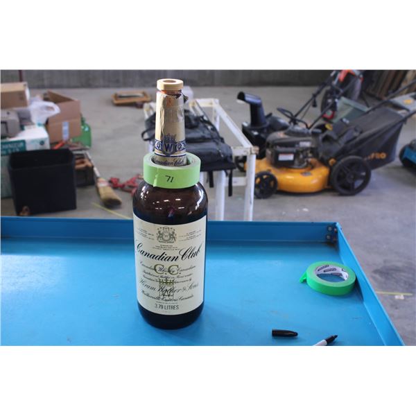 Empty Canadian Club whiskey bottle commonly used for storing change. The bottle features original la