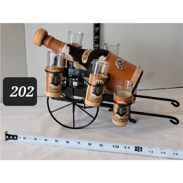 Leather & cow hyde wrapped Tequila bottle, shot glasses on metal wagon stand.