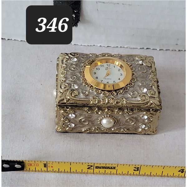 Heavy metal ornate trinket box. Enamel inside with time piece on top.