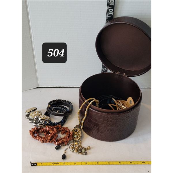 Padded round storage box & contents.Includes goldstone bracelets.