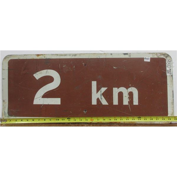 2 kms Brown Metal Highway Sign