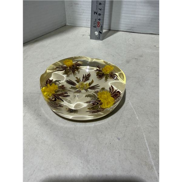 decorative collectible dish featuring preserved flowers suspended in clear resin.