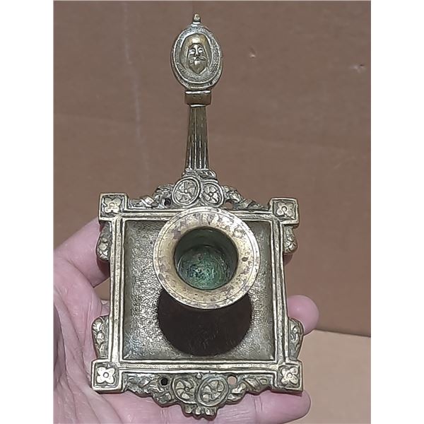 Vintage brass candlestick features a distinct square base with intricate detailing and an oval medal