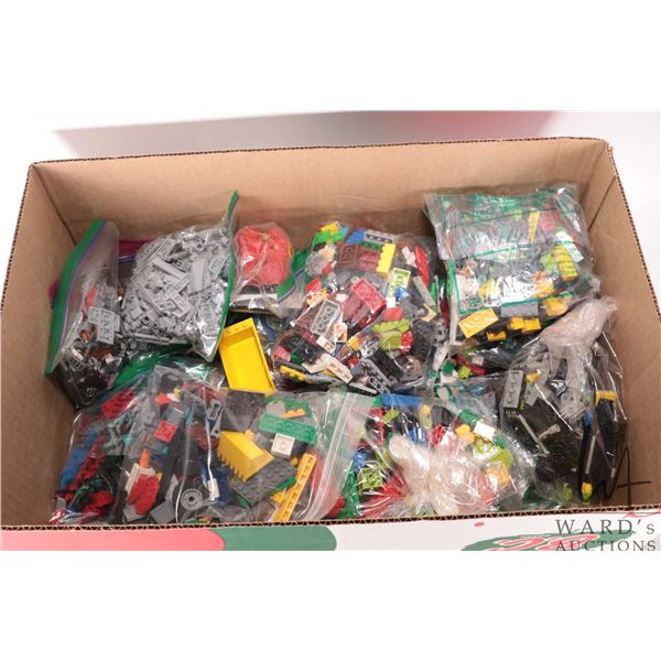 Box containing a large selection of bagged Lego bricks and accessories