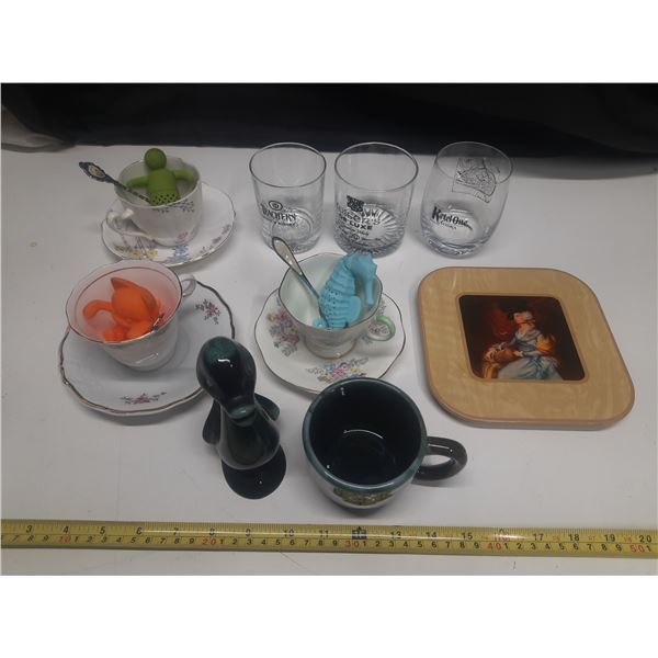 Collection of vintage drinking glasses and teacups, including several branded barware glasses.
